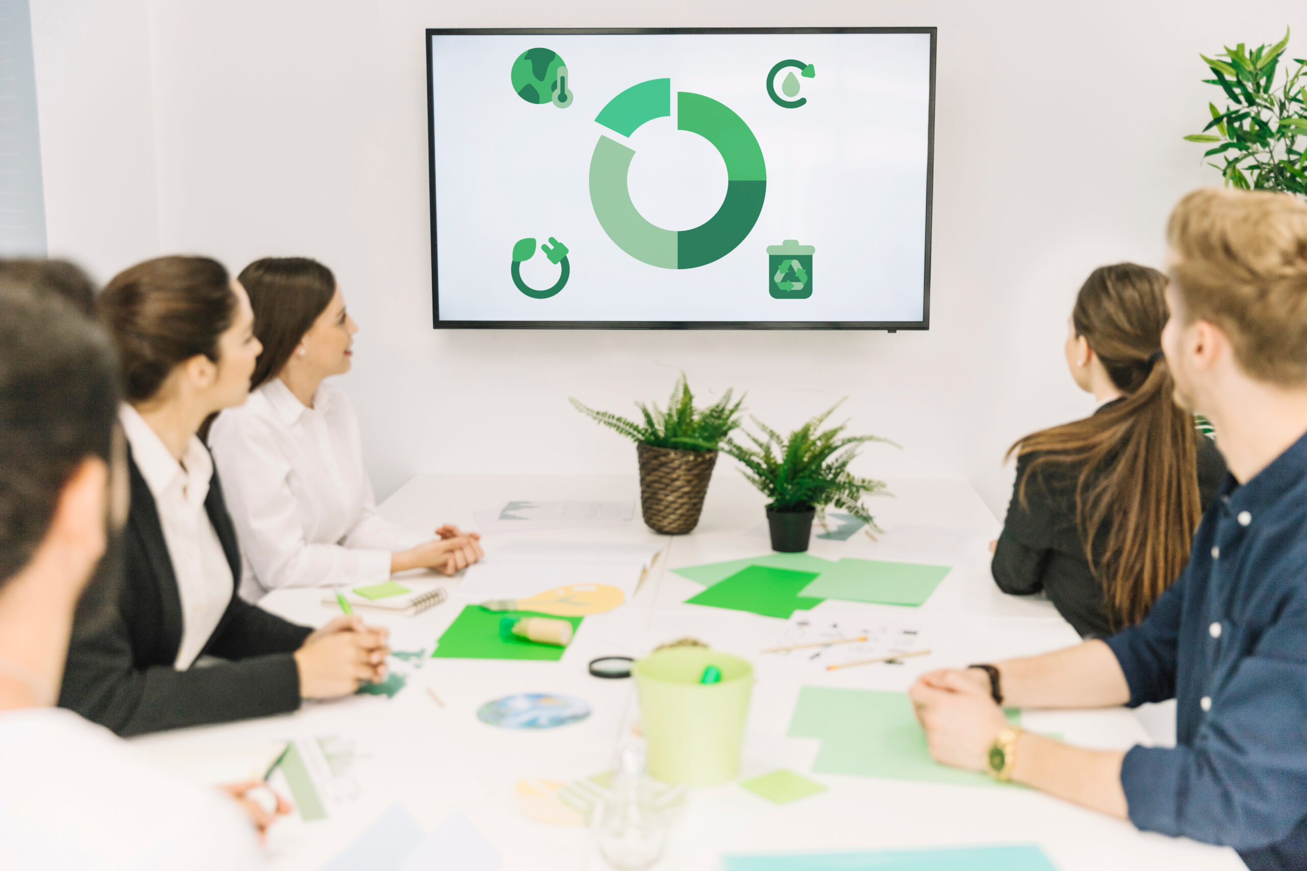 Image of people in a room looking at a pie chart on the screen.