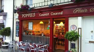 Picture of front of Poppies Cafe building with outdoor seating area.